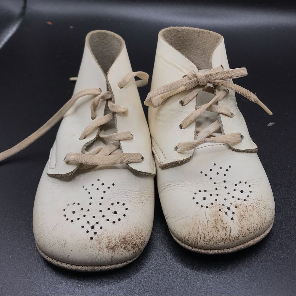 Used vintage white leather baby shoes decor